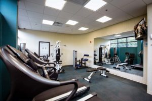 C Hotel gym with view of flatscreen tv and treadmills and other gym equipment